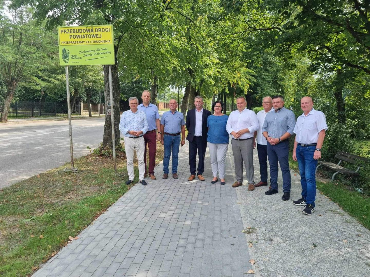 Mężczyźni i jedna kobieta stoją na wyremontowanej ulicy