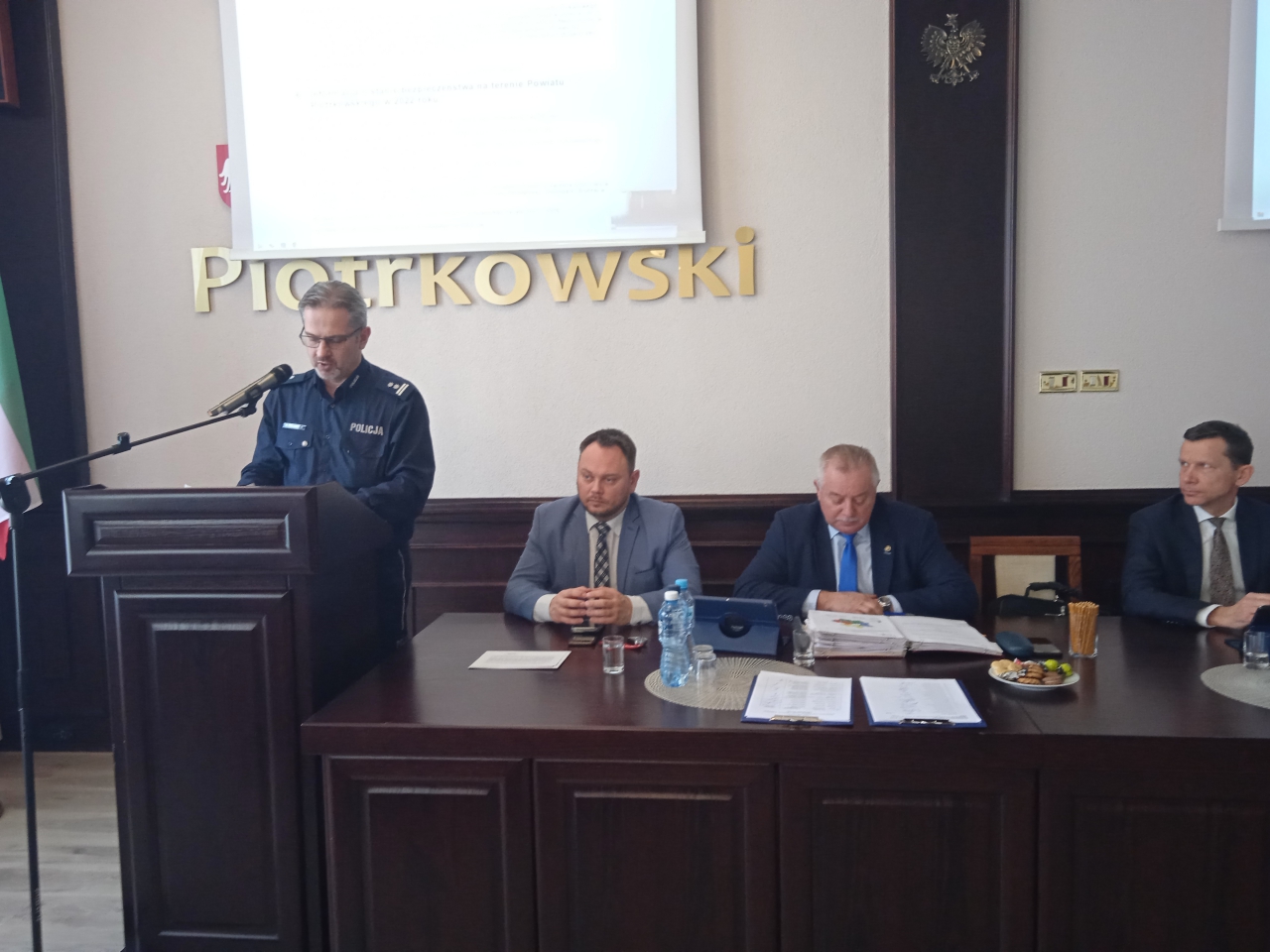 Przedstawiciel Policji wraz z radnymi znajduje się w sali konferencyjnej starostwa podczas Sesji.