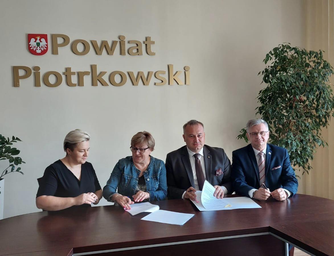 Władze Powiatu i Stowarzyszenia znajdują się w Sali konferencyjnej Starostwa. W tle napis Powiat Piotrkowski oraz herb Powiatu