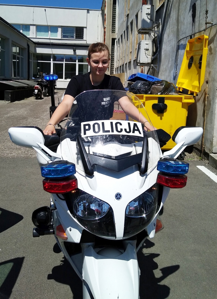 Dziewczyna siedzi na policyjnym motocyklu