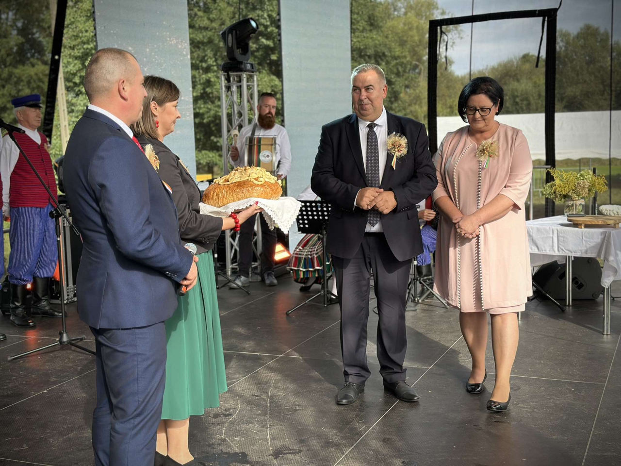 Starostowie dożynkowi wręczają chleb gospodarzom Ziemi Piotrkowskij