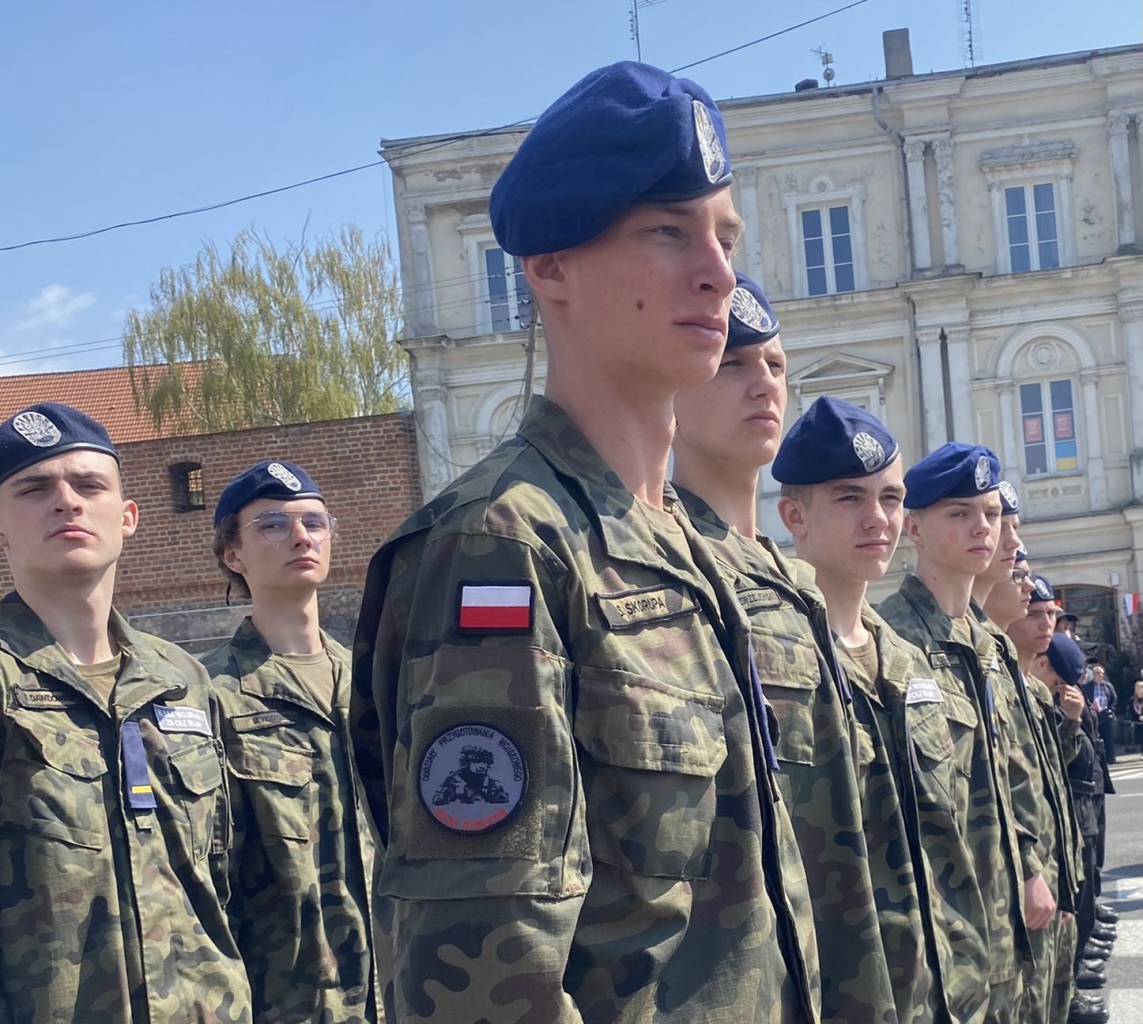 Młodzi chłopcy stoją na baczność w mundurach wojskowych