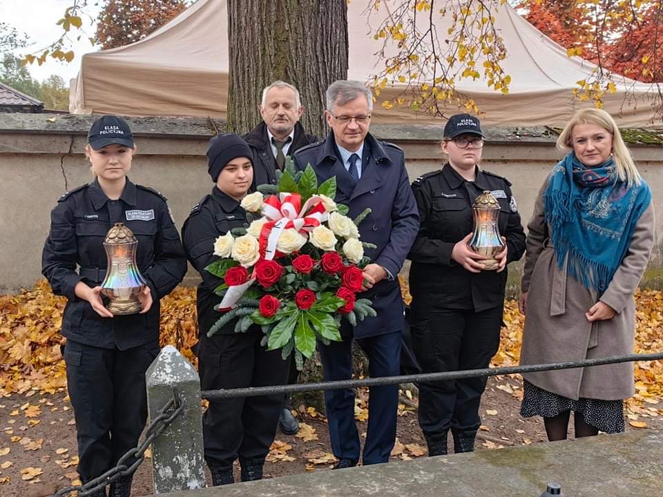 Wicestarosta stoi wraz z Dyrekcją oraz uczniami w Szkoły w Bujnach przy grobie profesora.