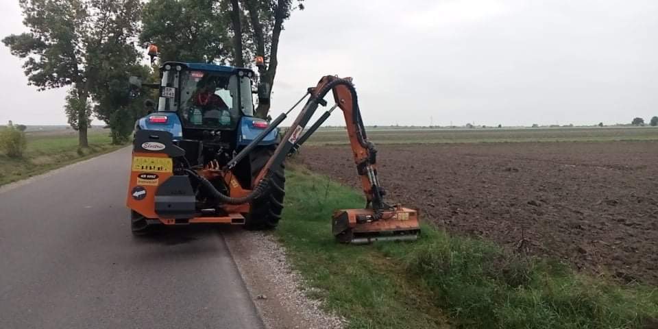 Koparka stoi na poboczu drogi.