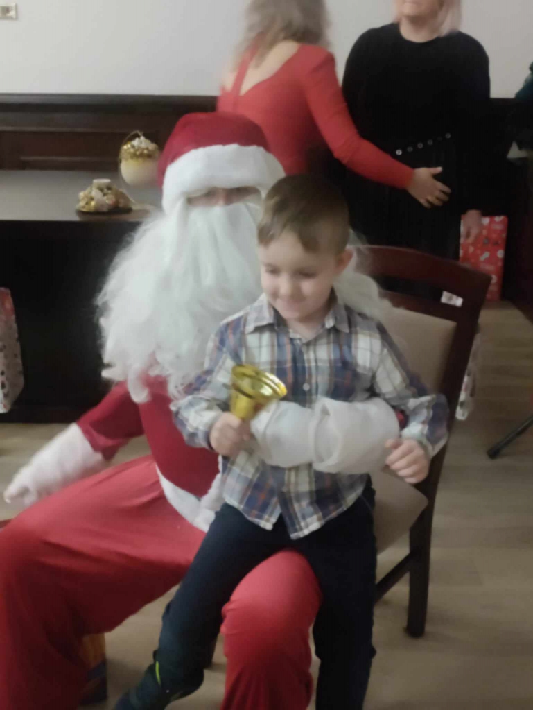 Maluszek siedzi na kolanach Mikołaja