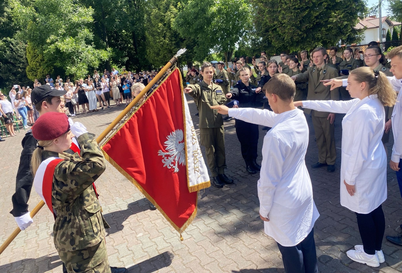 Delegowani reprezentanci klas pierwszych szkoły w Bujnach stoją przy sztandarze szkoły w czasie składania przysięgi