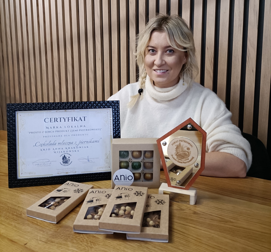 Producent czekolady Anio wraz ze swoimi produktami, certyfikatem Marki lokalnej prosto z serca przyznanym przez Powiat Piotrkowski oraz statuetką z napisem powiat Piotrkowski prosto z serca. Produkt Ziemi Piotrkowskiej.