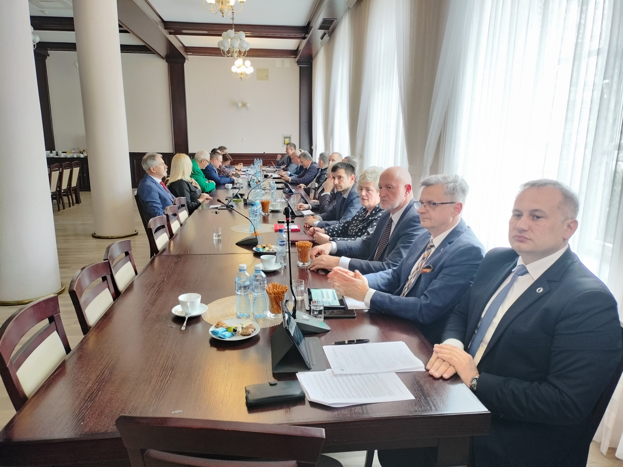Na zdjęciu członkowie Rady Powiatu siedzą za stołem w sali konferencyjnej Starostwa Powiatowego