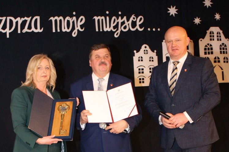 Władze Rozprzy stoją w pomieszczeniu z dokumentem oraz symbolicznymi kluczami do miasta
