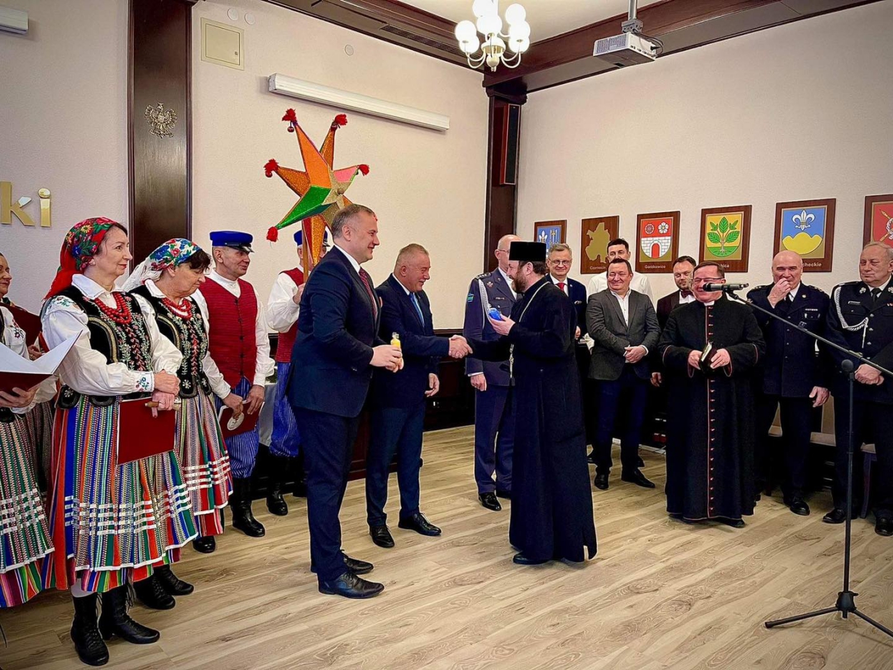 Starosta Piotr Wojtysiak wita gości zgromadzonych na spotkaniu opłatkowym w sali konferencyjnej piotrkowskiego Starostwa.