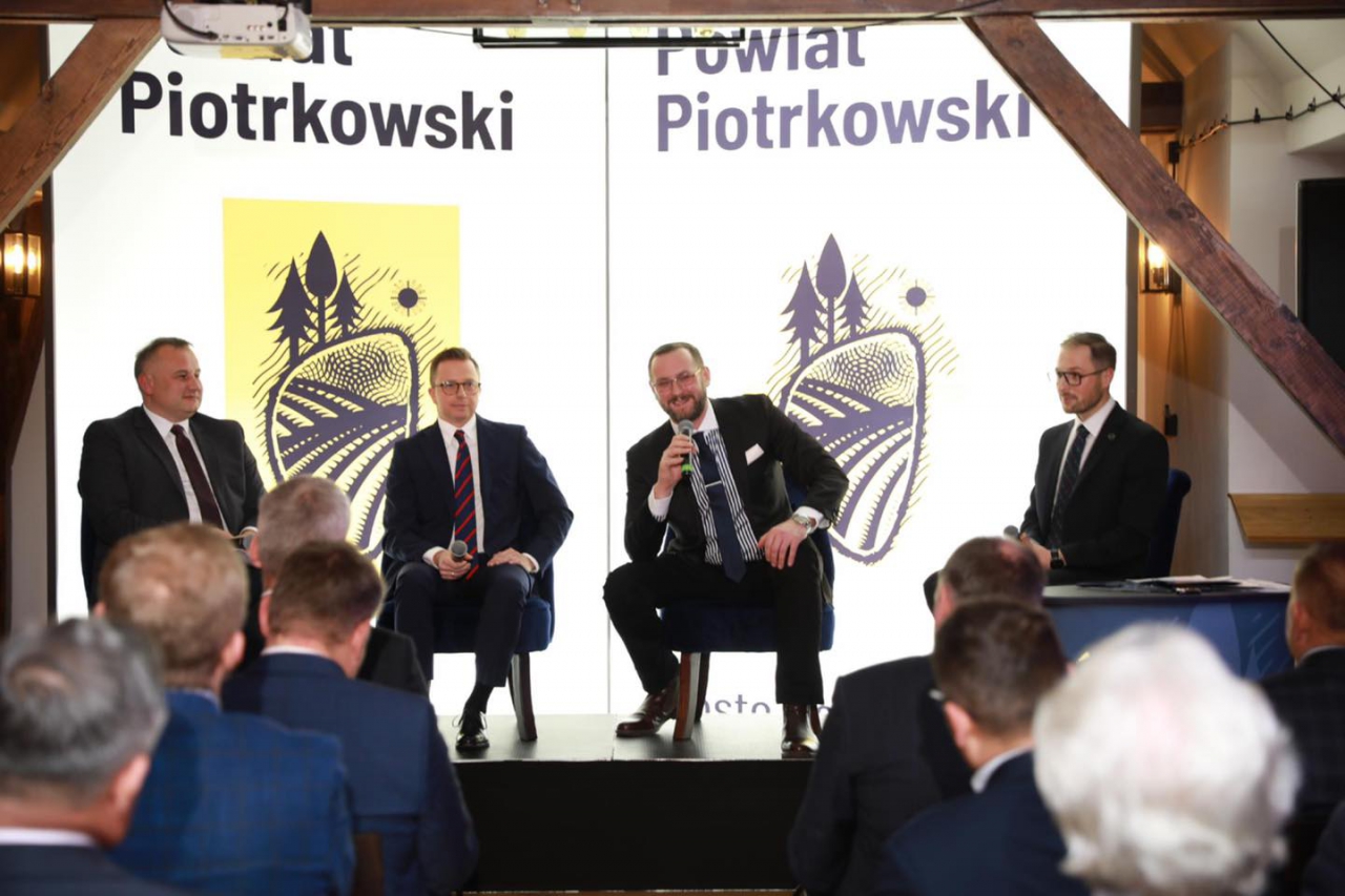 Starosta Piotr Wojtysiak oraz Uczestnicyw forum podczas panelu w sali konferencyjnej w Hotelu Podklasztorze. W tle napis Powiat Piotrkowski.