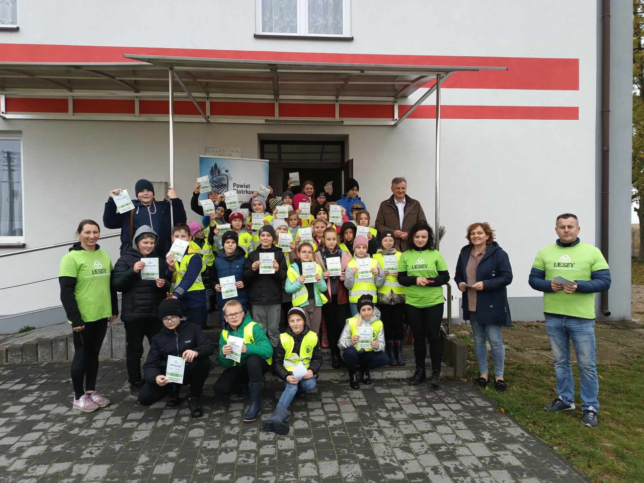 Wicestarosta stoi z uczestnikami wydarzenia przed budynkiem