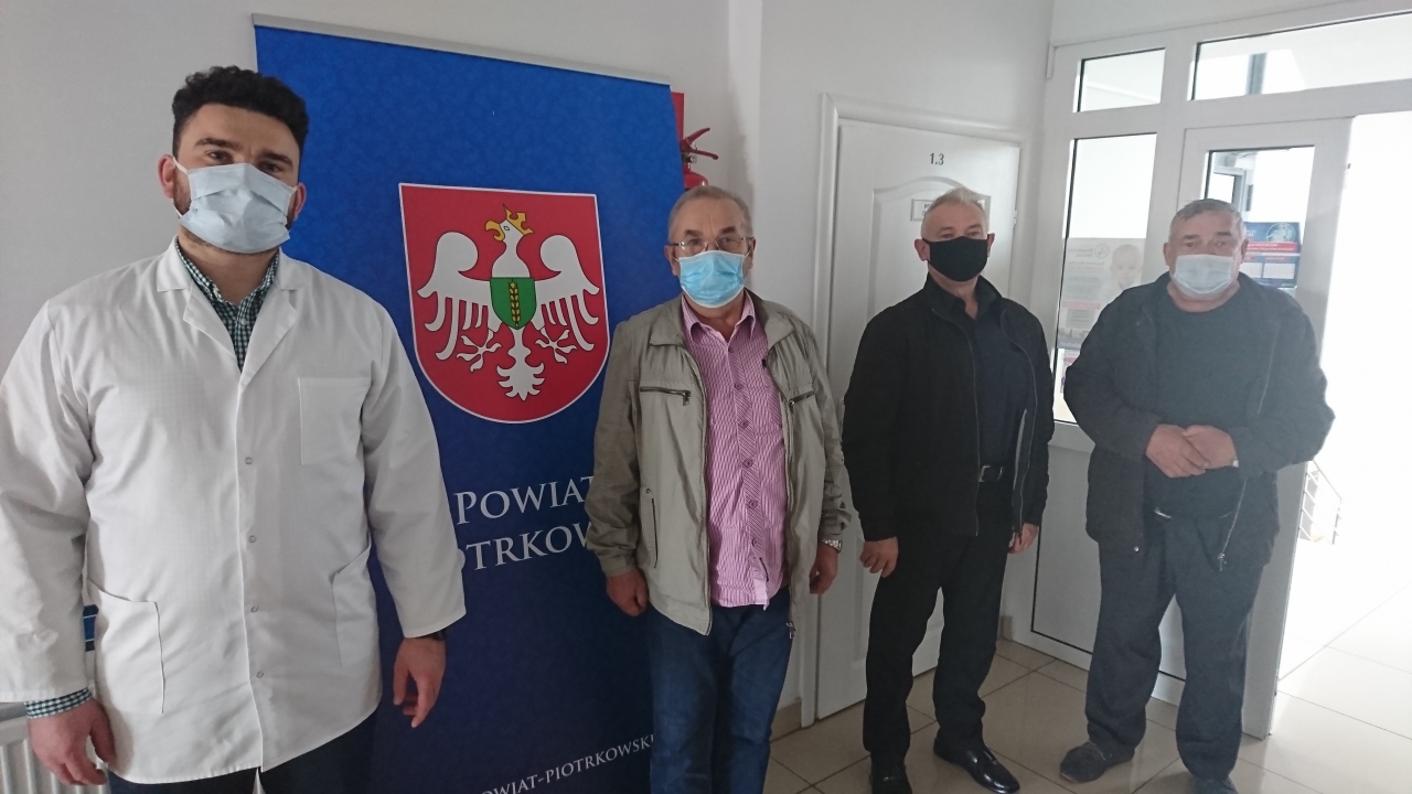 Lekarz i dwóch pacjentów stoi w przychodni.