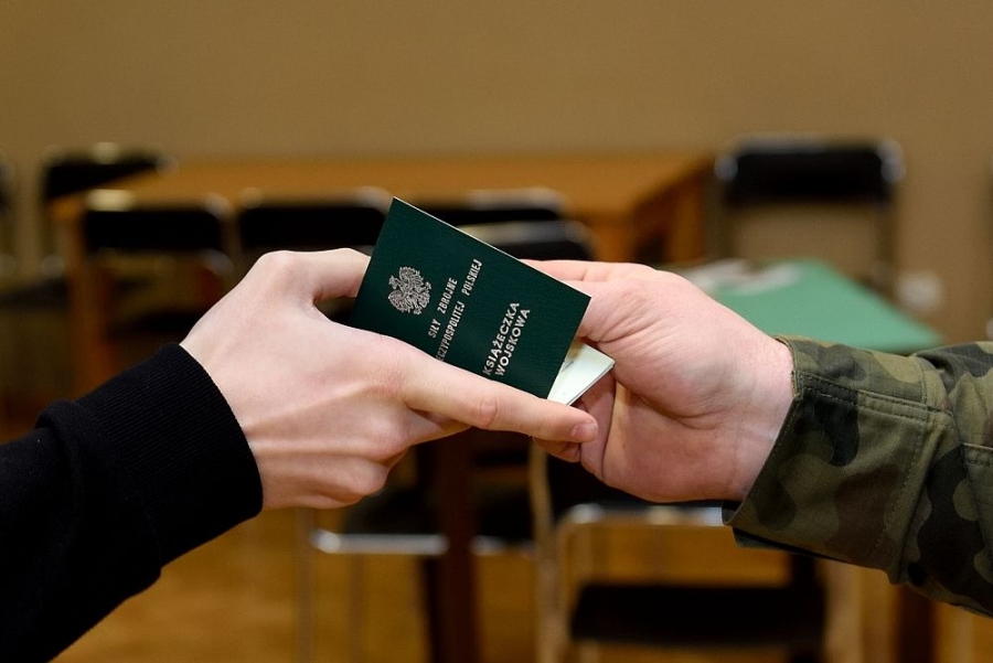 Książeczka wojskowa podawana z ręki do ręki