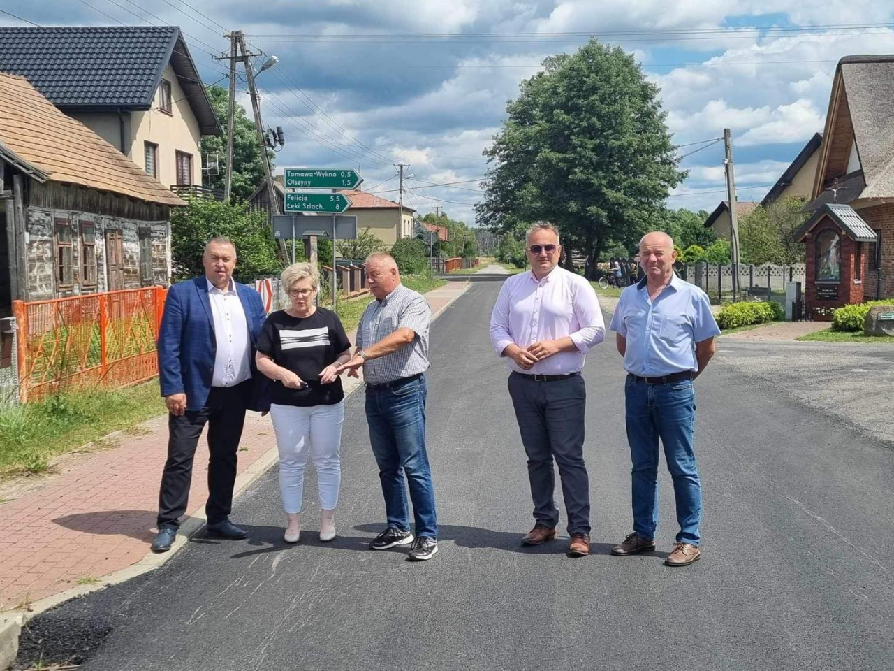 Przedstawiciele władz oglądają modernizowaną drogę w Tomawie