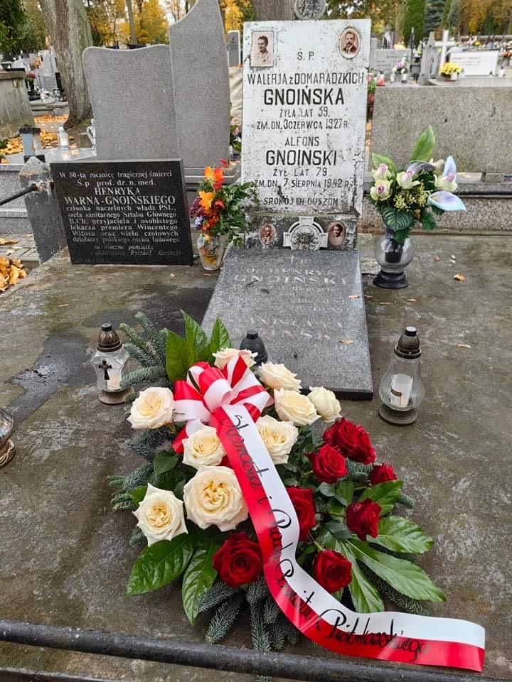 Grób rodziny Gnoińskich. Na nim wiązanka z biało czerwonych kwiatów.