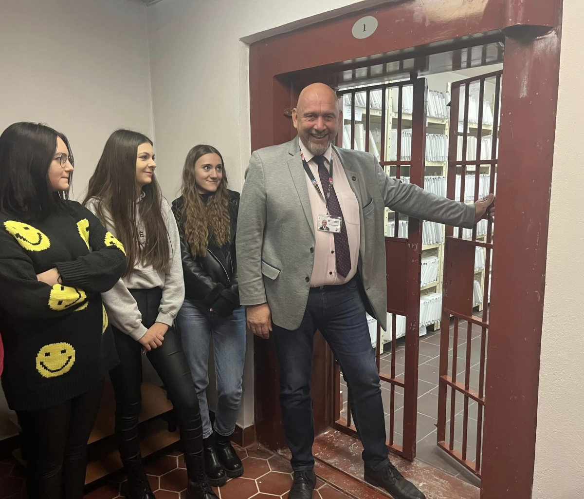 Sekretarz Powiatu wraz z uczniami stoi przy kratach