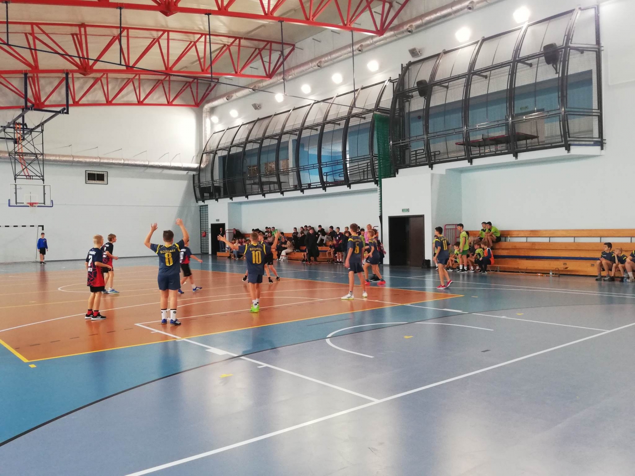 Zawodnicy grają w piłkę ręczną w hali sportowej