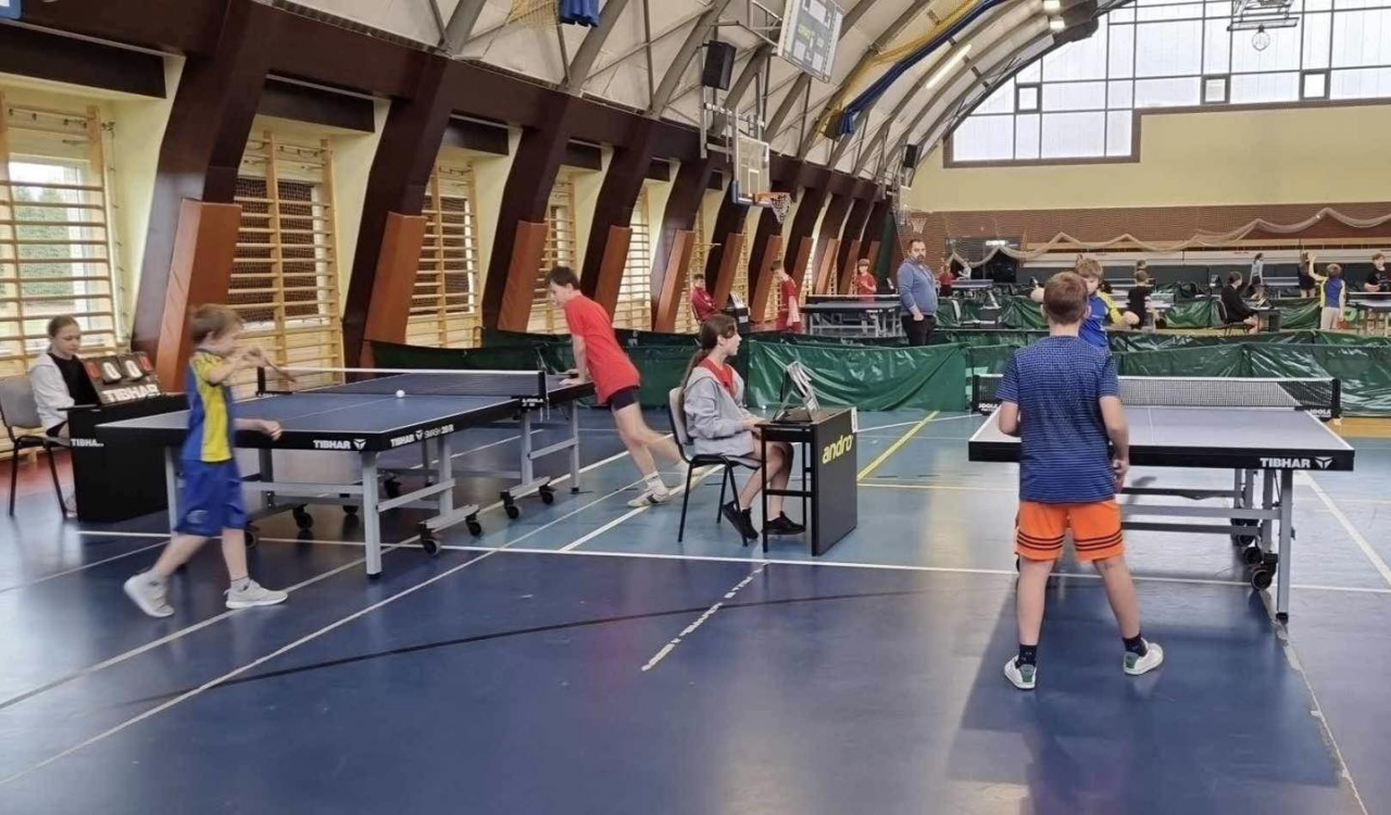 Zawodnicy w hali sportowej grają w tenisa