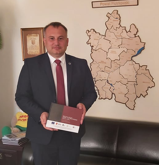 Starosta Piotr Wojtysiak prezentuje publikację Produkty lokalne Ziemi Piotrkowskie prosto z serca