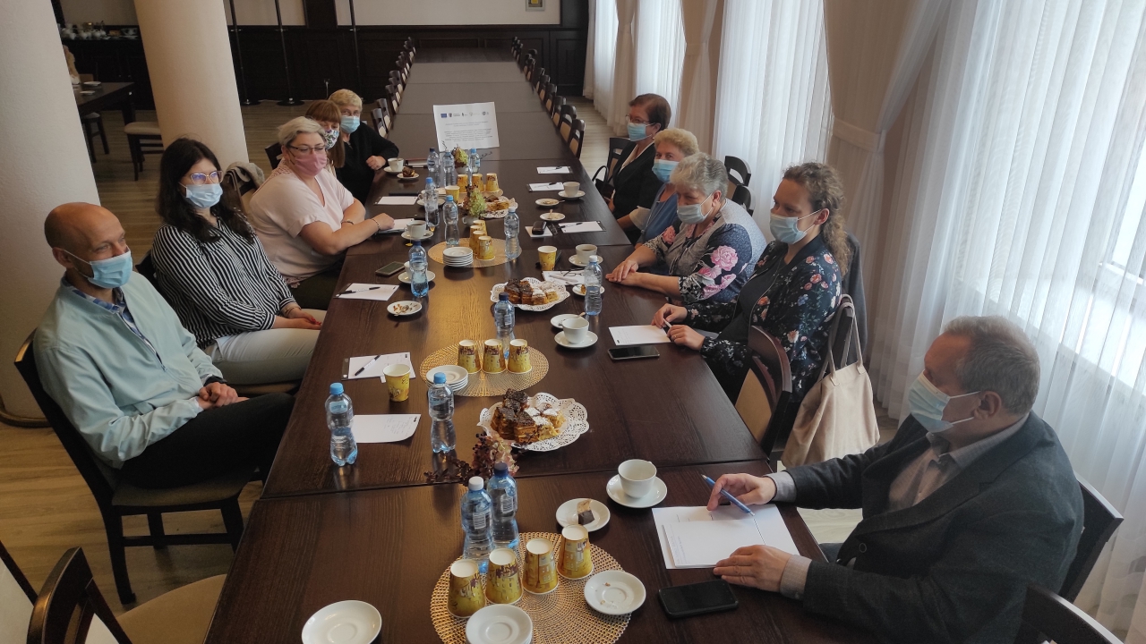 Grupa kilkunastu osób siedzi na sali konferencyjnej.
