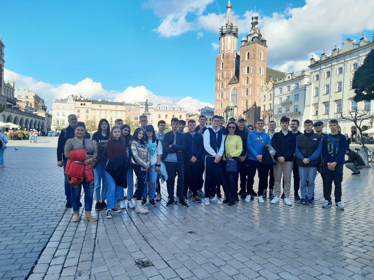 Uczestnicy wycieczki na krakowskim rynku. W tle Kościół Mariacki. 