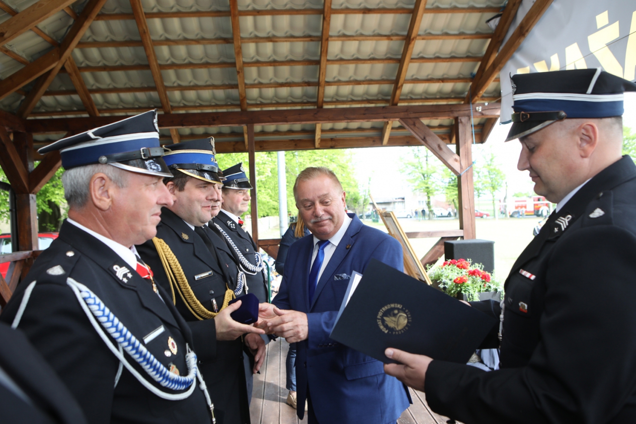 Wręczenie medali na scenie, stoi czterech mężczyzn