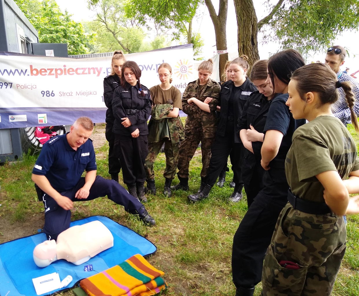 Młodzież obserwuje potencjalną akcję ratowniczą wykonywaną przez policjanta