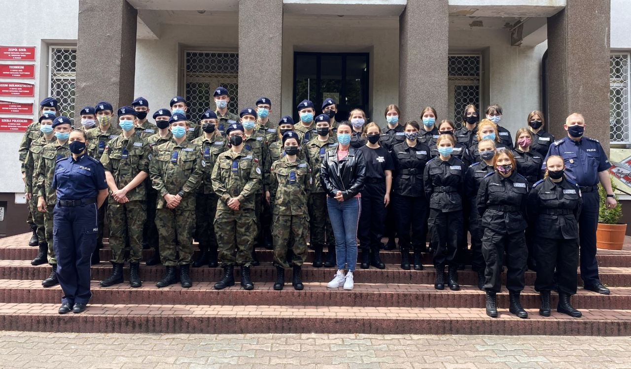 Komendant wraz uczniami klas mundurowych przed budynkiem szkoły w Bujnach