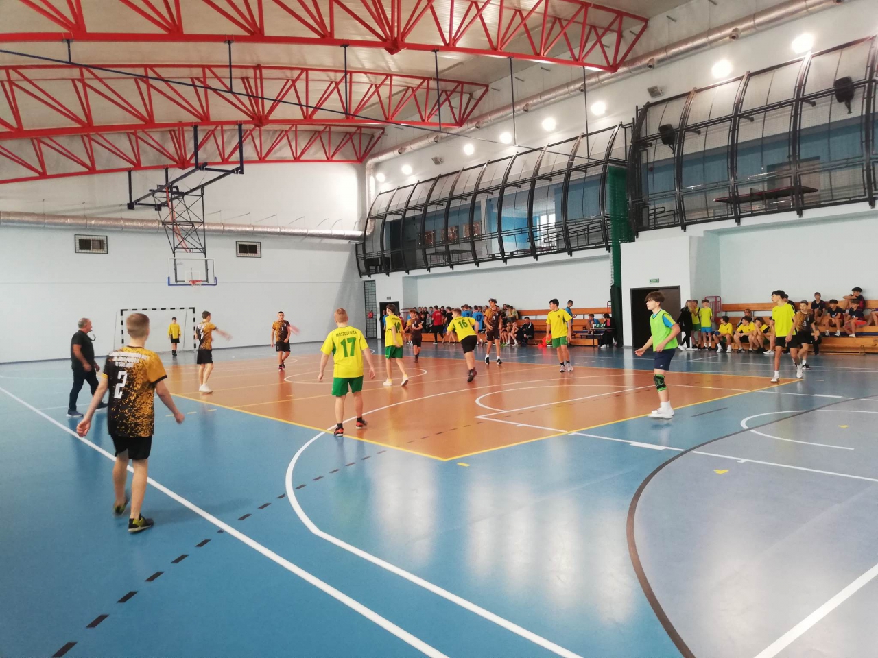 Zawodnicy grają w piłkę ręczną w hali sportowej
